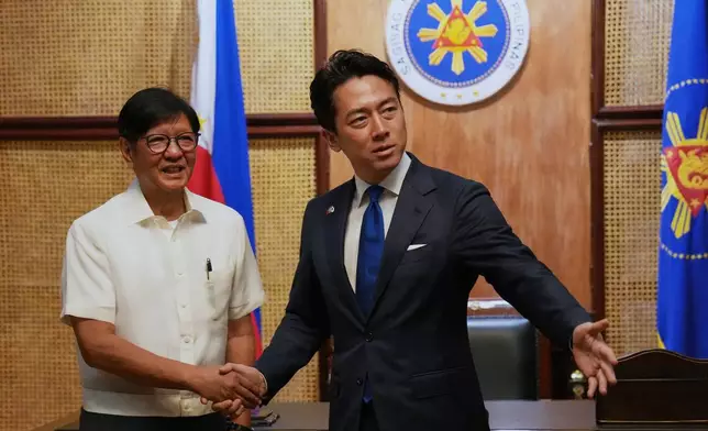 Philippine President Ferdinand Marcos Jr., left, greets Japan's Defense Minister Shinjiro Koizumi at the Malacanang presidential palace in Manila, Philippines on Tuesday, May 5, 2026. (AP Photo/Aaron Favila, Pool)