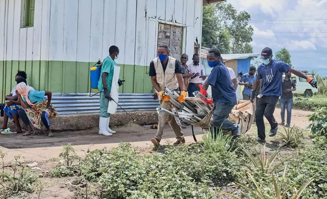 Aid workers carry supplies to set up an Ebola treatment center in Bunia, Congo, Tuesday, May 19, 2026. (AP Photo/Dirole Lotsima Dieudonne)