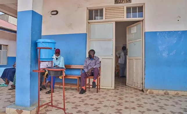 People wait outside a hospital reception in Bunia, Congo, Tuesday, May 19, 2026. (AP Photo/Dirole Lotsima Dieudonne)