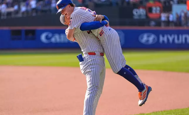 New York Mets' Carson Benge, right, is lifted off the ground by Juan Soto after Benge hit the game-winning fielders choice during the tenth inning of a baseball game against the New York Yankees, Sunday, May 17, 2026, in New York. (AP Photo/Seth Wenig)