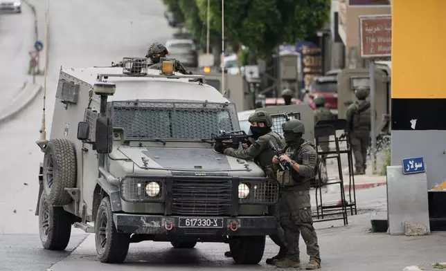 Israeli soldiers take positions during clashes with Palestinians in the West Bank city of Nablus, Sunday, May 3, 2026. (AP Photo/Majdi Mohammed)