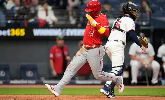 Los Angeles Angels' Oswald Peraza, left, scores behind Cleveland Guardians catcher Patrick Bailey, right, in the sixth inning of a baseball game in Cleveland, Tuesday, May 12, 2026. (AP Photo/Sue Ogrocki)