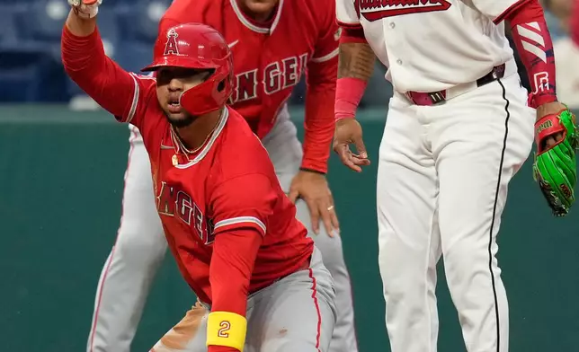 Los Angeles Angels' Oswald Peraza, left, gestures from third base next to Cleveland Guardians third baseman José Ramírez, right, after hitting a triple in the sixth inning of a baseball game in Cleveland, Tuesday, May 12, 2026. (AP Photo/Sue Ogrocki)