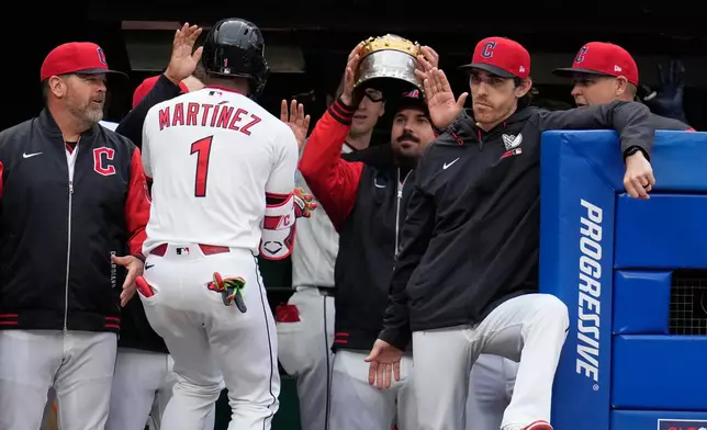Cleveland Guardians 'Angel Martínez (1) is greeted in the dugout after hitting a solo home run in the third inning of a baseball game against the Los Angeles Angels in Cleveland, Tuesday, May 12, 2026. (AP Photo/Sue Ogrocki)