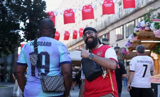 Arsenal supporters pose for a photo the day before the Champions League final soccer match between Paris Saint-Germain and Arsenal in Budapest, Hungary, Friday, May 29, 2026. (AP Photo/Armin Durgut)