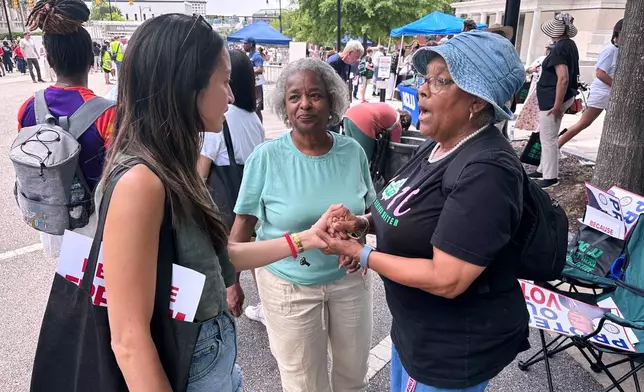 Bee Nguyen, left, talks to Carole Burton, center, and Tondalaire Ashford at a voting rights rally Saturday, May 16, 2026, in Montgomery, Ala. (AP Photo/Bill Barrow)