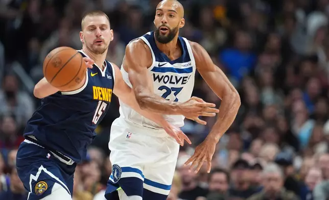 Denver Nuggets center Nikola Jokic, left, fights for control of the ball with Minnesota Timberwolves center Rudy Gobert in the second half in Game 5 of a first-round NBA playoffs basketball series Monday, April 27, 2026, in Denver. (AP Photo/David Zalubowski)