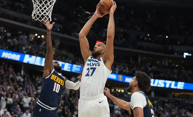 Minnesota Timberwolves center Rudy Gobert drives to the net between Denver Nuggets guard Tim Hardaway Jr., left, and forward Cameron Johnson in the second half in Game 5 of a first-round NBA playoffs basketball series Monday, April 27, 2026, in Denver. (AP Photo/David Zalubowski)