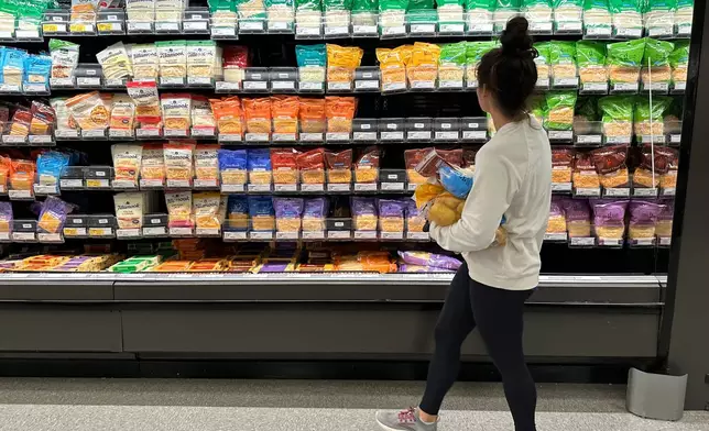 FILE - A shopper peruses cheese offerings at a Target store Wednesday, Oct. 4, 2023, in Sheridan, Colo. (AP Photo/David Zalubowski, File)