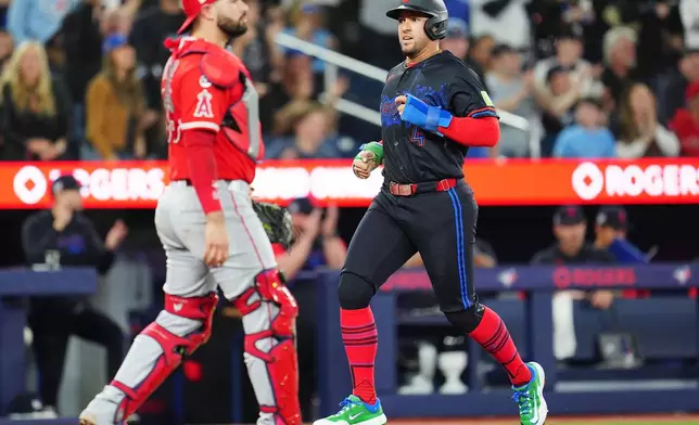 Toronto Blue Jays designated hitter George Springer (4) scores as Los Angeles Angels catcher Sebastian Rivero, left, looks on during third-inning baseball game action in Toronto, Friday, May 8, 2026. (Frank Gunn/The Canadian Press via AP)