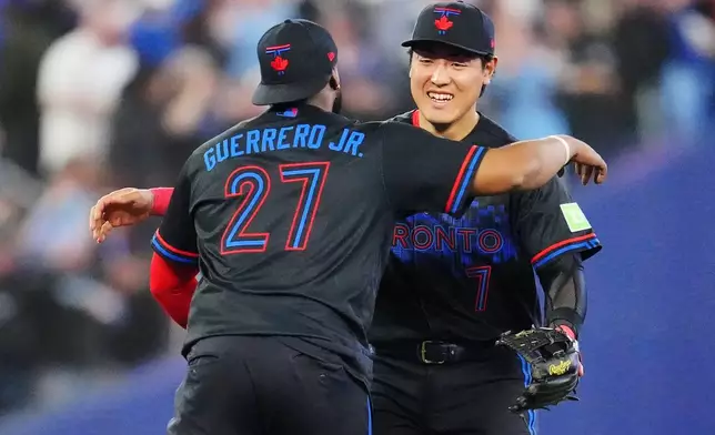 Toronto Blue Jays' Vladimir Guerrero Jr. (27) and Kazuma Okamoto (7) celebrate after defeating the Los Angeles Angels in a baseball game in Toronto, Friday, May 8, 2026. (Frank Gunn/The Canadian Press via AP)