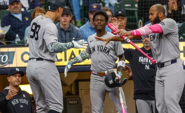 New York Yankees' Aaron Judge (99) reacts with Jazz Chisholm Jr., center, and Amed Rosario, right, after his home run during the first inning against the Milwaukee Brewers Sunday, May 10, 2026, in Milwaukee. (AP Photo/Jeffrey Phelps)