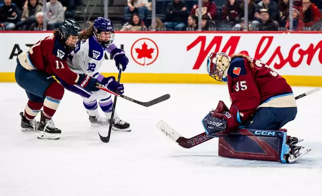 Montréal Victoire goaltender Ann-Renée Desbiens (35) makes a save against Minnesota Frost's Kelly Pannek (12) while Montréal Victoire's Abby Roque (11) defends, during second overtime period of an PWHL playoff hockey game in Laval, Que., on Tuesday, May 5, 2026. (Christopher Katsarov/The Canadian Press via AP)