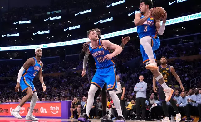 Oklahoma City Thunder guard Jared McCain, second from right, passes the ball as guard Shai Gilgeous-Alexander, left, center Isaiah Hartenstein, second from left, Los Angeles Lakers center Deandre Ayton, center, and guard Marcus Smart, right, watch during the first half of Game 4 in a second-round NBA basketball playoffs series Monday, May 11, 2026, in Los Angeles. (AP Photo/Mark J. Terrill)