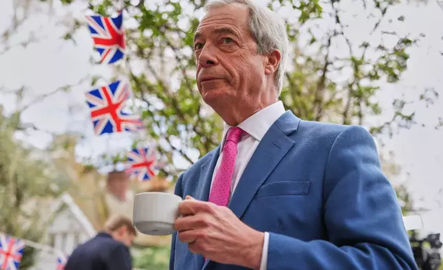 FILE - Nigel Farage, the leader of Reform UK, drinks a cup of tea as he meets supporters after a news conference in London on April 2, 2026. (AP Photo/Kirsty Wigglesworth, File)
