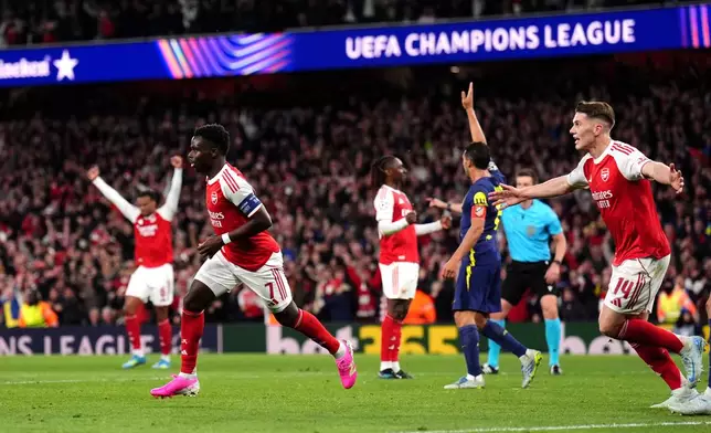 Arsenal's Bukayo Saka, left, celebrates after scoring the opening goal during a Champions League semifinal, second leg, soccer match between Arsenal and Atletico Madrid in London, Tuesday, May 5, 2026. (John Walton/PA via AP)