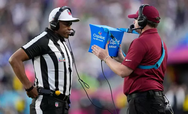 FILE - Referee Shawn Smith, left, reviews a play during the NFL Super Bowl 60 football game between the Seattle Seahawks and the New England Patriots, Sunday, Feb. 8, 2026, in Santa Clara, Calif. (AP Photo/Julio Cortez, File)
