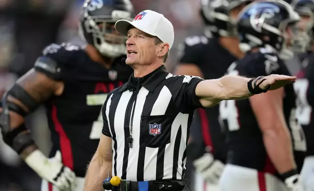 FILE - Referee Land Clark annouces a penalty during the second half of an NFL football game between the Arizona Cardinals and the Atlanta Falcons Sunday, Dec. 21, 2025, in Glendale, Ariz. (AP Photo/Ross D. Franklin, File)