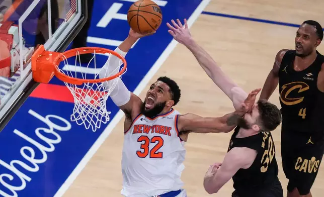 New York Knicks center Karl-Anthony Towns (32) shoots against Cleveland Cavaliers forward Dean Wade (32) during the second half of Game 1 in the Eastern Conference finals NBA basketball playoffs series Tuesday, May 19, 2026, in New York. (AP Photo/Yuki Iwamura)