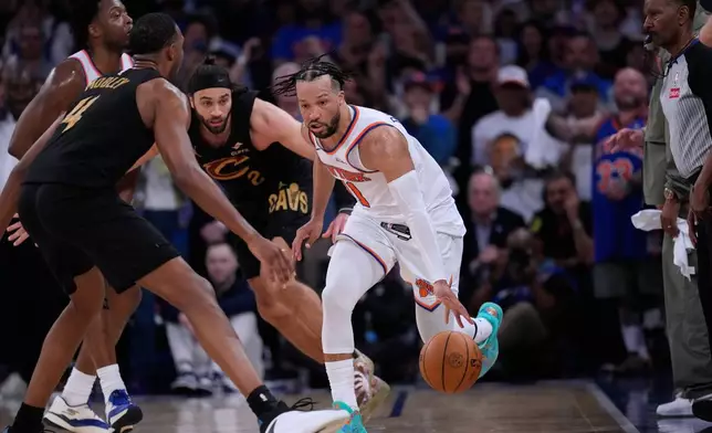 New York Knicks' Jalen Brunson, right, brings the ball up the court during the overtime period of Game 1 in the Eastern Conference finals NBA basketball playoffs series against the Cleveland Cavaliers, Tuesday, May 19, 2026, in New York. (AP Photo/Seth Wenig)