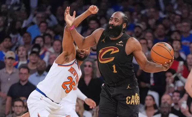 New York Knicks' Mikal Bridges, left, covers Cleveland Cavaliers' James Harden during the overtime period of Game 1 in the Eastern Conference finals NBA basketball playoffs series Tuesday, May 19, 2026, in New York. (AP Photo/Seth Wenig)