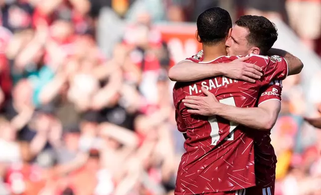 Liverpool's Mohamed Salah, back to the camera, hugs team-mate Liverpool's Andrew Robertson as he is substituted off on his final appearance during the Premier League match between Liverpool and Brentford, in Liverpool, England, Sunday May 24, 2026. (Peter Byrne/PA via AP)