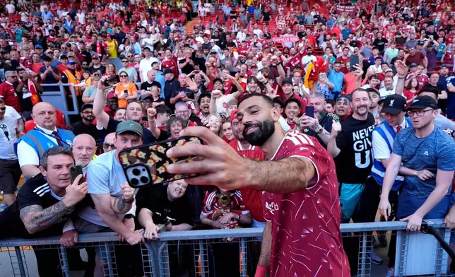 Liverpool's Mohamed Salah takes a selfie with fans following his final Liverpool appearance in the Premier League match at Anfield, Liverpool, England, Sunday May 24, 2026. (Peter Byrne/PA via AP)