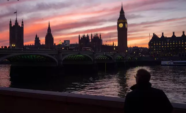 FILE - A man walks along the south bank of the River Thames backdropped by the Elizabeth Tower, known as Big Ben, of the Houses of Parliament, in London, Tuesday, Jan. 17, 2023. (AP Photo/Kin Cheung, File)