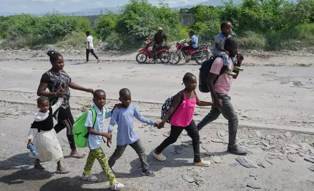 Residents flee their homes to escape clashes between armed gangs in Port-au-Prince, Haiti, Monday, May 11, 2026. (AP Photo/Odelyn Joseph)