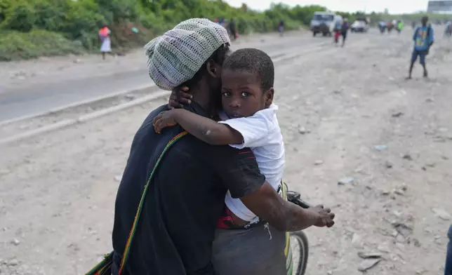 Residents flee their homes to escape clashes between armed gangs in Port-au-Prince, Haiti, Monday, May 11, 2026. (AP Photo/Odelyn Joseph)