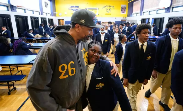 Former NBA basketball player Jalen Rose hugs a student at the Jalen Rose Leadership Academy, Monday, April 20, 2026, in Detroit. (AP Photo/Paul Sancya)