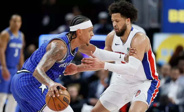 Orlando Magic forward Paolo Banchero, left, drives against Detroit Pistons guard Cade Cunningham, right, during the first half in Game 7 of a first-round NBA basketball playoffs series Sunday, May 3, 2026, in Detroit. (AP Photo/Duane Burleson)