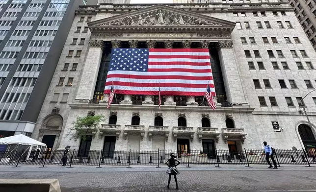 FILE - People pass the New York Stock Exchange on May 28, 2024, in New York. (AP Photo/Peter Morgan, File)