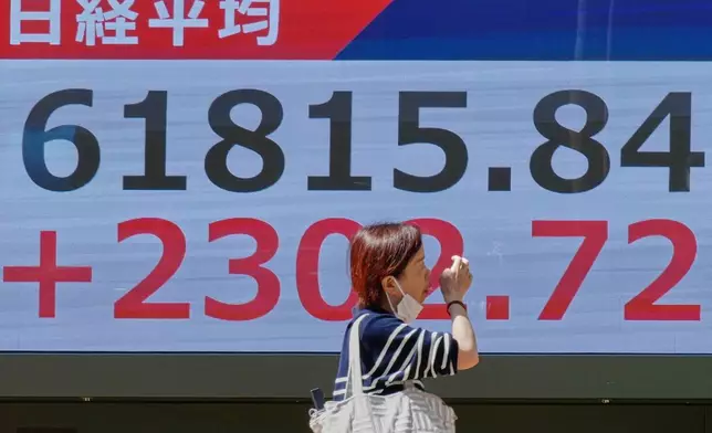 A person walks in front of an electronic stock board showing Japan's Nikkei index at a securities firm Thursday, May 7, 2026, in Tokyo. (AP Photo/Eugene Hoshiko)