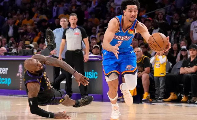 Oklahoma City Thunder guard Jared McCain, right, drives toward the basket as Los Angeles Lakers forward LeBron James falls during the second half of Game 4 in a second-round NBA basketball playoffs series Monday, May 11, 2026, in Los Angeles. (AP Photo/Mark J. Terrill)