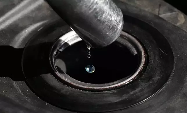 FILE - Gasoline drops from the nozzle of a fuel pump as it fills a motorcycle as prices continue to rise at a gasoline station in Quezon City, Philippines on March 19, 2026. (AP Photo/Aaron Favila, File)