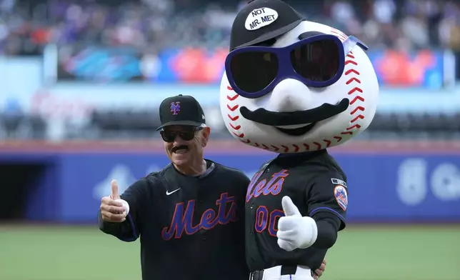 Former New York Mets manager Bobby Valentine, left, poses with Mr. Met after throwing out a ceremonial first pitch before a baseball game between the Mets and the Miami Marlins, Friday, May 29, 2026, in New York. (AP Photo/Pamela Smith)
