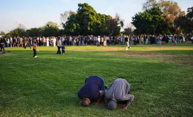 Two people pray during a vigil, the day after a shooting, outside of the Islamic Center of San Diego, Tuesday, May 19, 2026, in San Diego. (AP Photo/Jae C. Hong)