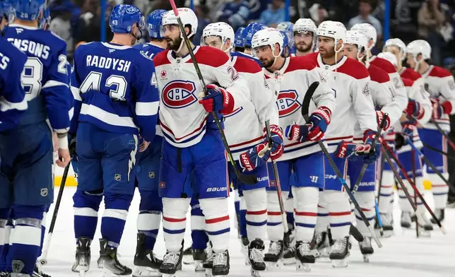 Montréal Canadiens center Phillip Danault (24) leads the team through the handshake line after the Canadiens defeated the Lightning in Game 7 of an NHL hockey Stanley Cup first-round playoff series, Sunday, May 3, 2026, in Tampa, Fla. (AP Photo/Chris O'Meara)