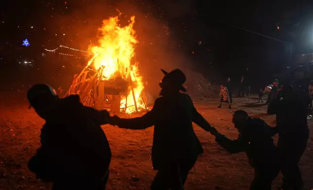 Ultra-Orthodox Jews dance around a bonfire during Lag BaOmer, a Jewish holiday traditionally marked by bonfire, music, and communal celebrations, in Netanya, Israel, Monday, May 4, 2026. (AP Photo/Ariel Schalit)