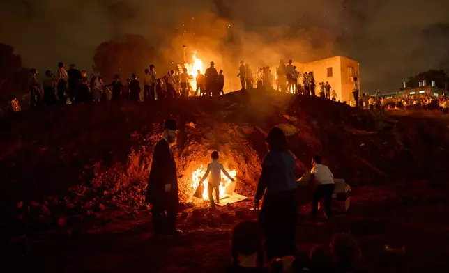Ultra-Orthodox Jews dance around a bonfire during Lag BaOmer, a Jewish holiday traditionally marked by bonfire, music, and communal celebrations, in Bnei Brak, Israel, Monday, May 4, 2026. (AP Photo/Oded Balilty)