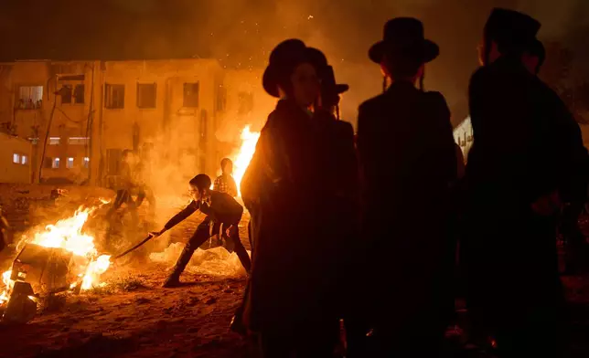 Ultra-Orthodox Jews gather around a bonfire during Lag BaOmer, a Jewish holiday traditionally marked by bonfire, music, and communal celebrations, in Bnei Brak, Israel, on Monday, May 4, 2026. (AP Photo/Oded Balilty)