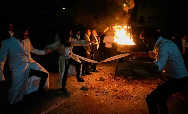 Ultra-Orthodox Jews dance around a bonfire during Lag BaOmer, a Jewish holiday traditionally celebrated with bonfires, music, and gatherings, at the Orthodox neighborhood of Mea Shearim, in Jerusalem, Monday, May 4, 2026. (AP Photo/Ohad Zwigenberg)