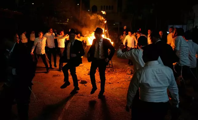 Ultra-Orthodox Jews dance around a bonfire during Lag BaOmer, a Jewish holiday traditionally celebrated with bonfires, music, and gatherings, at the Orthodox neighborhood of Mea Shearim, in Jerusalem, Monday, May 4, 2026. (AP Photo/Ohad Zwigenberg)