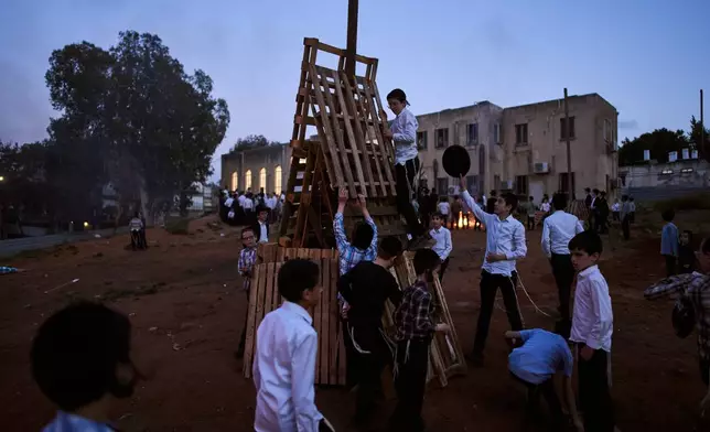 Ultra-Orthodox Jewish children build bonfires in preparation for Lag BaOmer, a Jewish holiday traditionally marked by bonfire, music, and communal celebrations, in Bnei Brak, Israel, Monday, May 4, 2026. (AP Photo/Oded Balilty)