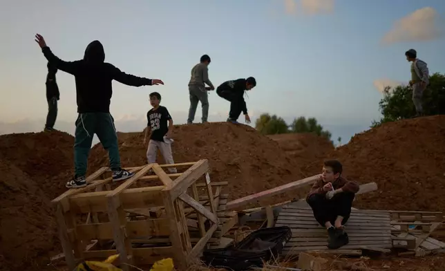 Children collect wood for a a bonfire during Lag BaOmer celebrations in Netanya, Israel, Monday, May 4, 2026. (AP Photo/Ariel Schalit)