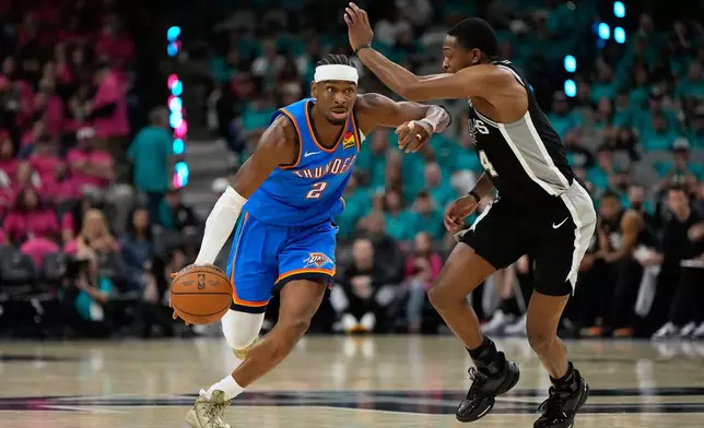 Oklahoma City Thunder guard Shai Gilgeous-Alexander (2) works toward the basket as San Antonio Spurs guard De'aaron Fox (4) defends during the second half of Game 3 in the Western Conference finals NBA basketball playoffs series Friday, May 22, 2026, in San Antonio. (AP Photo/Ashley Landis)