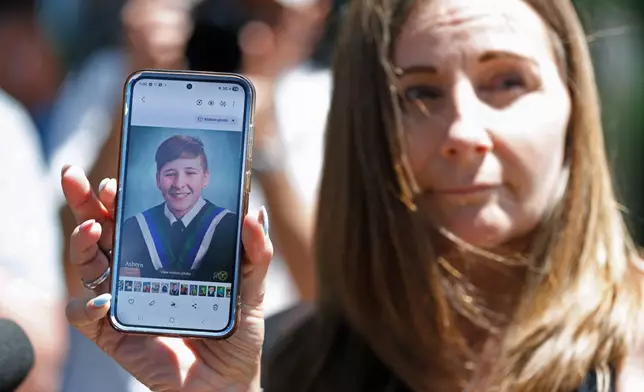 Kim Prosser holds a photo of her son Ashtyn outside the Ontario Court of Justice, Friday, May 29, 2026, in Newmarket, Ontario, after Kenneth Law pleaded guilty to 14 counts of counseling or aiding suicide, including the death of Prosser's son. (Christopher Drost/The Canadian Press via AP)