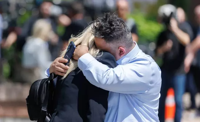 Leonardo Bedoya embraces his wife Maria Lopez outside the Ontario Court of Justice, Friday, May 29, 2026, in Newmarket, Ontario, after Kenneth Law pleaded guilty to 14 counts of counseling or aiding suicide, including the death of Bedoya's 18-year-old daughter, Jeshennia. (Christopher Drost/The Canadian Press via AP)