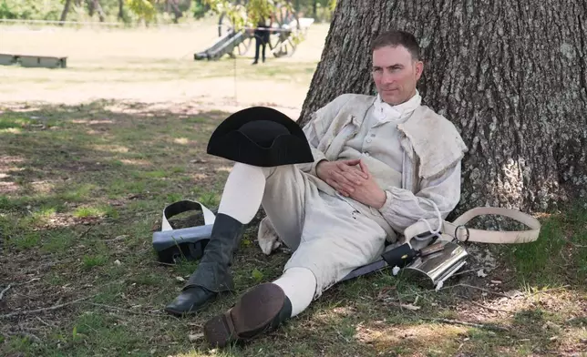 Army officer Jason Monhollen rests beneath a tree during a Revolutionary War event, in which he portrays a private in the 2nd North Carolina Infantry Regiment, in Halifax, N.C., on April 11, 2026. (AP Photo/Allen G. Breed)